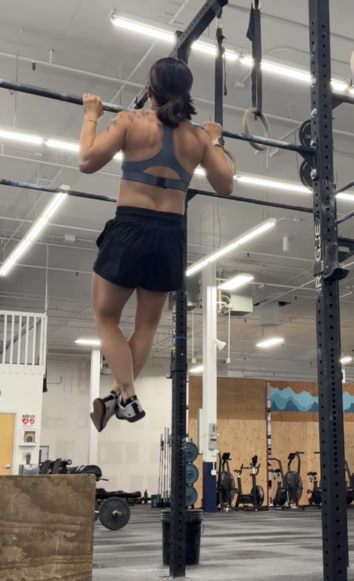 Dr. Erica Tran performing a pull-up at the gym